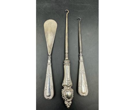 Silver handled items to include two button hooks and a shoehorn
