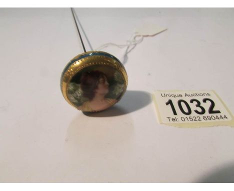 An early 20th century hat pin with portrait of a lady (possibly hand painted).