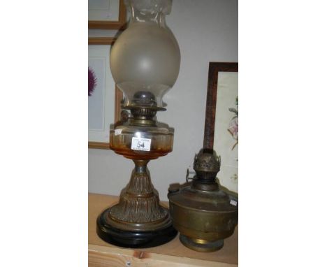 An oil lamp with glass font and a brass oil lamp font.