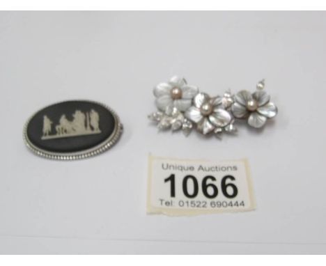 A black Wedgwood brooch in a silver mount together with a mother of pearl brooch set with cultured pearls in a white metal mo