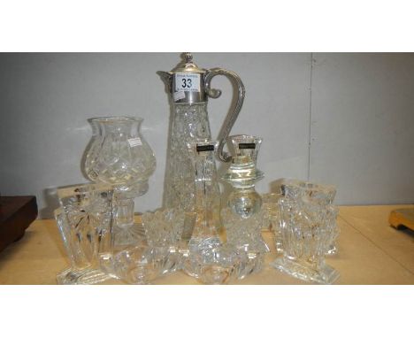 A glass claret jug, a glass candle lamp, a pair of candlesticks and a pair of salts.