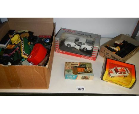 A shelf of boxed and unboxed die cast models etc.,