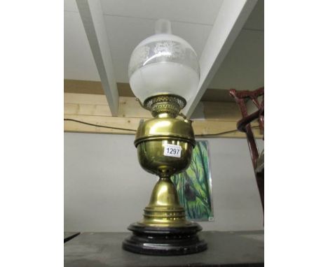A brass oil lamp on pot base complete with chimney and later shade.