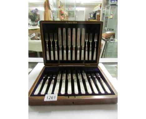 An Edwardian oak cased 24 piece set of fruit cutlery with mother of pearl handles and silver collars, hall marked Stevenson &