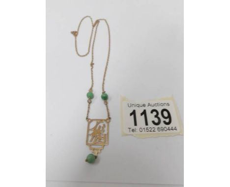 A jade/gold fine chain necklace.