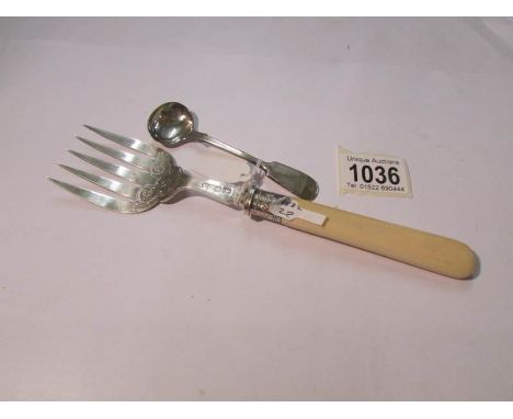 A silver fish serving fork and a large silver mustard spoon.