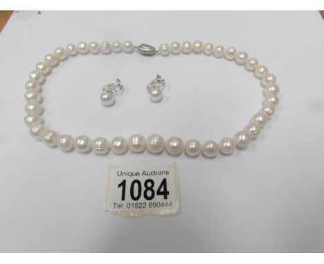 A white Honora pearl necklace with clip earrings.