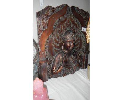 A carved wood panel depicting an Indian Deity.