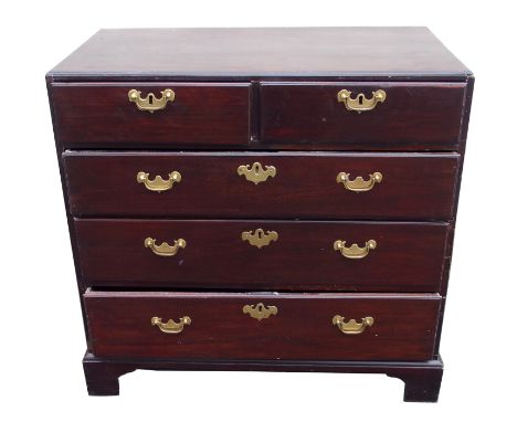 A GEORGIAN MAHOGANY CHEST the caddy shaped top above two short and three long graduating drawers with brass bail handles on b