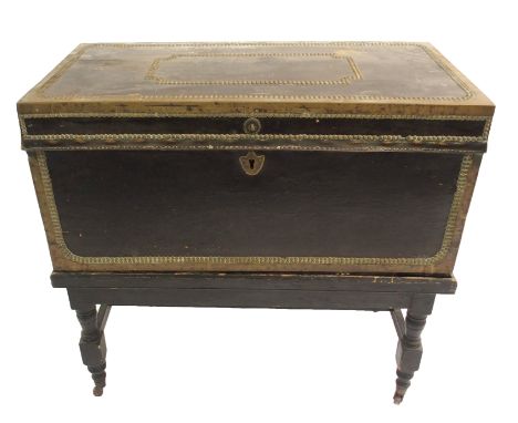 A NAVAL LEATHER BOUND AND BRASS MOUNTED CAMPHORWOOD TRUNK  the hinged top above bail carrying handles, shield shaped escutche