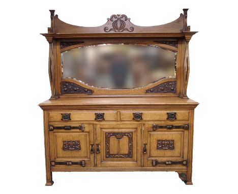 AN ARTS AND CRAFTS MIRROR BACK SIDEBOARD with two drawers over three carved cupboard doors, decorated with pomegranates and f