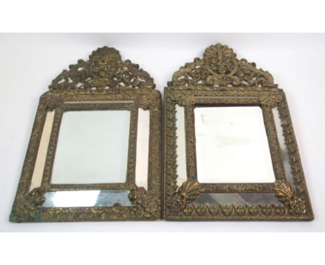 FOUR VICTORIAN ROCOCO STYLE BRASS WALL MIRRORS with bevelled edge central mirror and sloping side plates, all of differing de