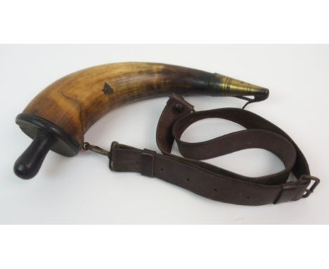 AN ANTIQUE MILITARY ISSUE HORN POWDER FLASK with brass nozzle and leather shoulder strap, marked with an arrow and WD, 32cm l