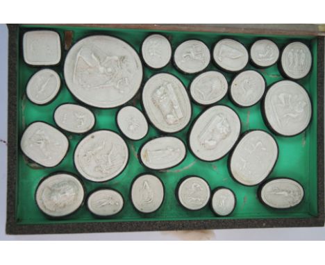 A COLLECTION OF 19TH CENTURY GRAND TOUR PLASTER MEDALLIONS of classical portrait cameos, in a faux double sided book case wit