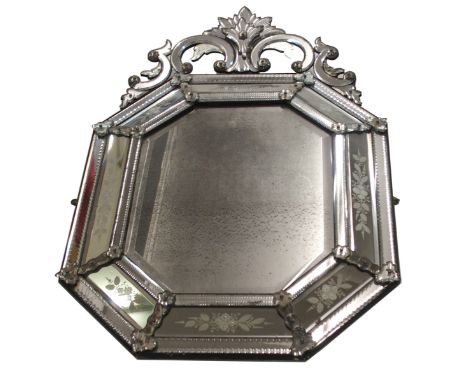 AN ITALIAN OCTAGONAL WALL MIRROR set with scrolling surmount above acid-etched raised panels and divided by flowerheads, 110c