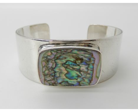 A SILVER RETRO BANGLE BY DANISH DESIGNER PALLE BISGAARD set with a panel of paua shell, inner dimension 5.4cm, width 2.2cm, w