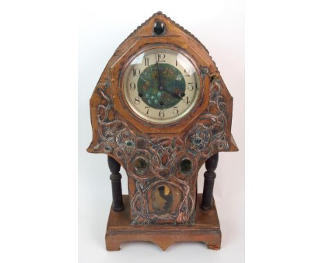 AN ARTS AND CRAFTS STYLE CLOCK the case covered in copper and with relief decoration of scrolling foliage, set with Scottish 