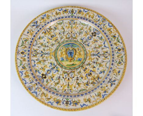 A LARGE ITALIAN MAJOLICA CHARGER  decorated with cherubs, mythical beasts and swags surrounding a central painted panel, with