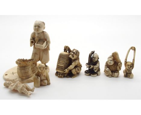 A JAPANESE IVORY OKIMONO ONI holding a temple bell enclosing another demon, 5cm high, a netsuke of a man seated eating, 3.5cm