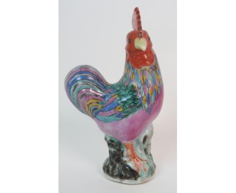 A CHINESE EXPORT MODEL OF A COCKEREL with red comb and coloured plumage on a rockwork base, 22cm high Condition Report: Avail