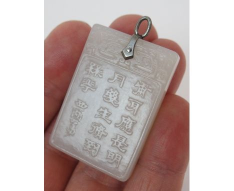 A CHINESE JADE RECTANGULAR PENDANT  carved to one side with a figure of Guanjin, the other side with rows of calligraphy, fit