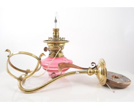 Brass wall lamp, cranberry glass reservoir, adapted for a electricity, 36cm deep.