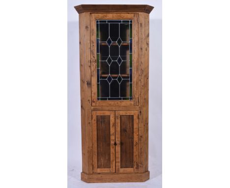 Pine freestanding corner cupboard, leaded glazed door to the upper section, two panel doors below, height 184cm.