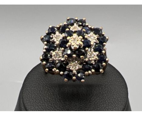 Ladies 9ct gold sapphire and diamond cluster ring. Comprising of 24 blue sapphires and 7 round brilliant cut diamonds. 5g siz