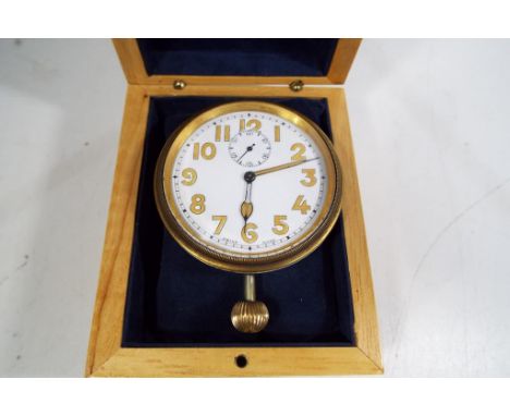 A white metal travel / car clock with a white dial, Swiss made with Arabic numerals and second dial, diameter of watch 6.5cm 