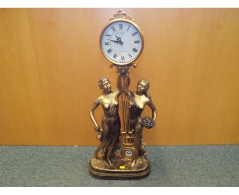 A contemporary Art Nouveau styled swinging mantel clock, the clock held aloft by two figurines of scantily clad maidens, in a