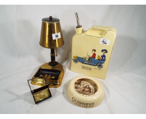 An unusual cigarette holder and ashtray in the form of a table lamp, a matchbox case, and a novelty ceramic ashtray advertisi