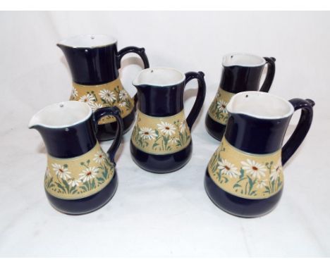A collection of five graduated ceramic Lovatt Langley ware jugs on a blue ground with a floral relied decoration banding (5)