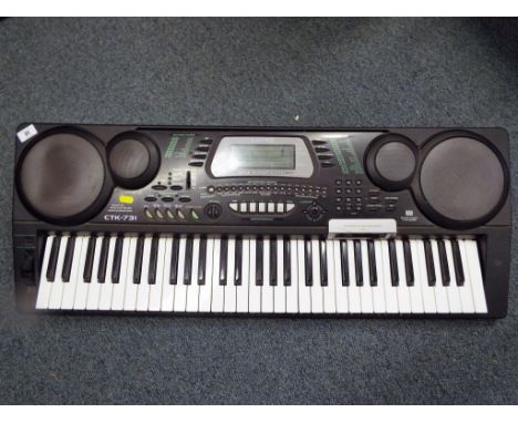A Casio CTK-731 multi-function electronic keyboard together with a General Motors in-car 6-disc CD autochanger unit - Est £20
