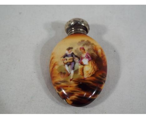 A good quality ceramic oval perfume bottle decorated with a depiction of a lady and gentleman clad in period costume, with a 