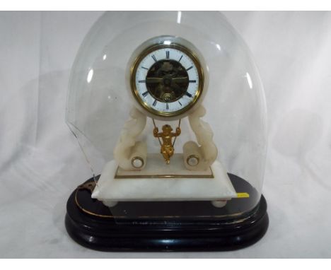 A late 19 th century mantel clock in the form of an alabaster arch with a cherub figure on a swing as the pendulum, the 8-day
