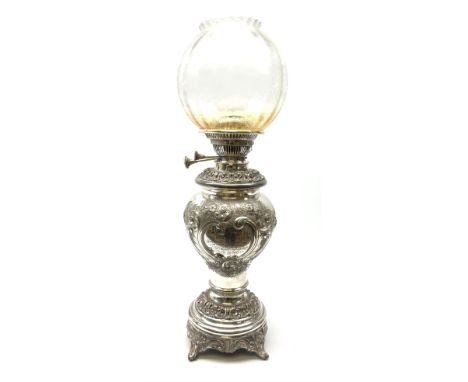 A Victorian silver plated oil lamp, of baluster form upon four scroll feet, decorated with presentation inscription within a 