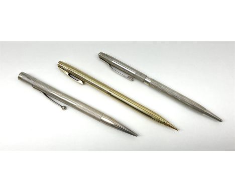 Two silver cased propelling pencils, with engine turned decoration, hallmarked W M Ltd, Birmingham 1948 and 1972, plus a gold