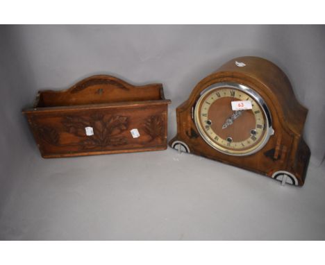 An arts and craft style hand made and carved newspaper box and a mantle clock