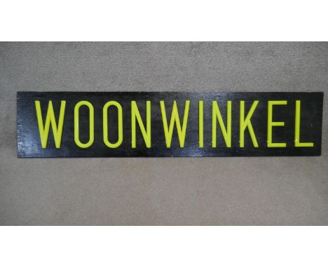 A very large light up sign with neon yellow lettering 'WOONWINKEL'. H.44 W.200cm 