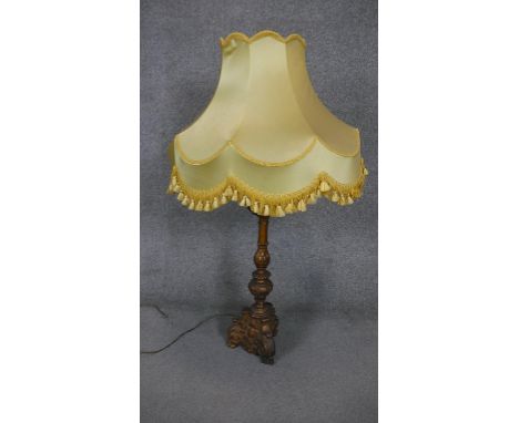 A gilt plaster foliate design table lamp with yellow silk shade with tassles. H.105 