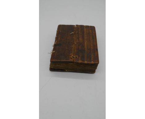 A 19th century Ethiopian coptic manuscript on vellum in wooden boards. Handwritten script in red and black ink. H.17 W.13cm 