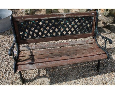 Slatted wooden bench with cast iron lattice type back, raised on cast iron supports of scrolled form, approx 125cm W x 81cm H