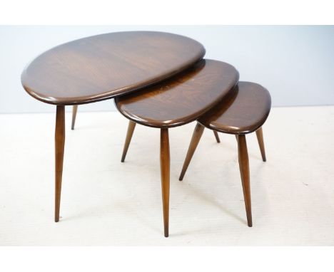 Ercol nest of three dark elm pebble tables (lacking maker's labels), largest table 41cm high x 65cm wide 
