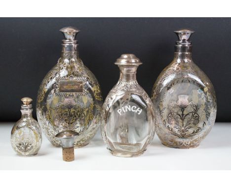 Set of three glass decanters of pinched form, the decanters with white metal overlay in the form of thistles (tallest approx 