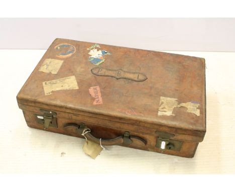 Vintage leather suitcase complete with travel labels and stickers to the front with double locks. Measures 68cm wide.