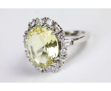 Silver and yellow stone dress ring having a halo of white accent stones. Band marked s925. Size P.5. 