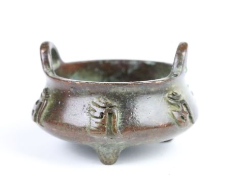Cast bronze censer with wing handles and three moulded feet. Measures 5.5cm wide.
