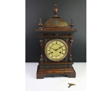 Antique mantel clock with attractive carved wood case, complete with key. 50cm high, 27cm wide and 15cm deep. 