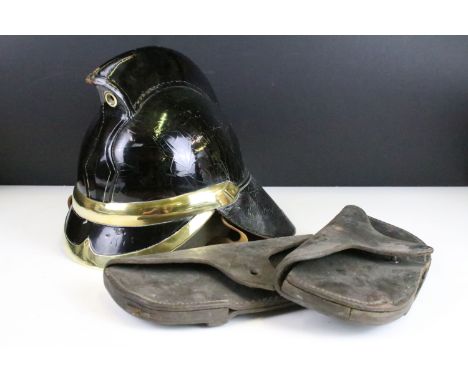 A vintage black leather firemans helmet with brass fittings together with two leather pouches. 