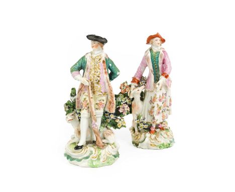 A Near Pair of Derby Porcelain Figures, circa 1770, modelled as a sportsman and his companion, stood before flowering bocages